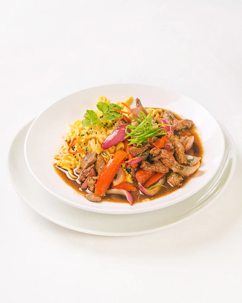 Fetuccini y lomo saltado frente